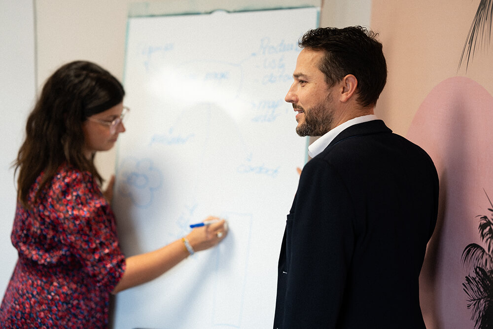 4 collaborateurs (idéalement 1 inté + cdp + seo + dir cli) en salle de réu devant wireframe ou arbo ZKO affiché à l'écran